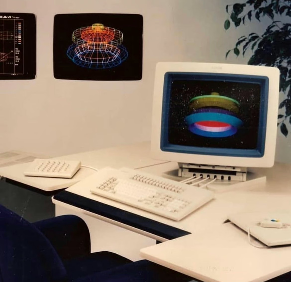 Vintage CAD workstation with a colorful wireframe torus render on screen